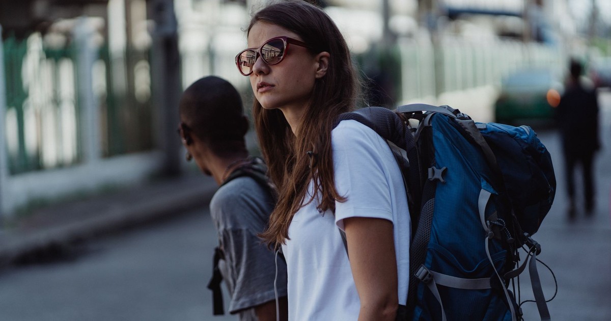 A young woman with a backpack explores the city, embracing urban travel and adventure.