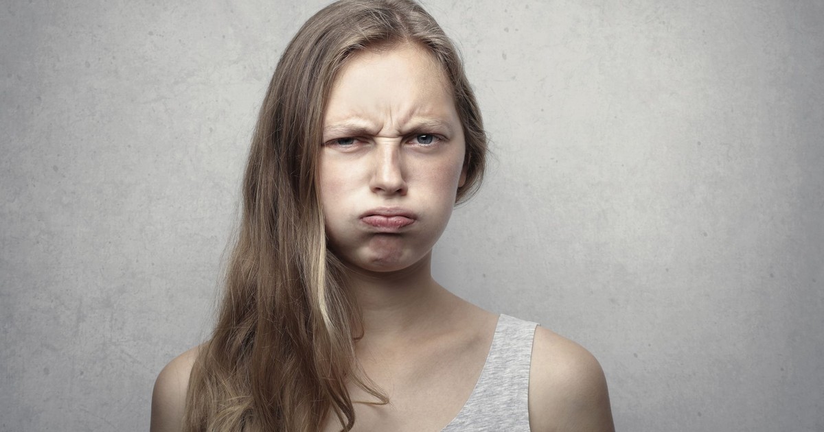 Close-up portrait of a young woman with a pensive expression in a studio setting.