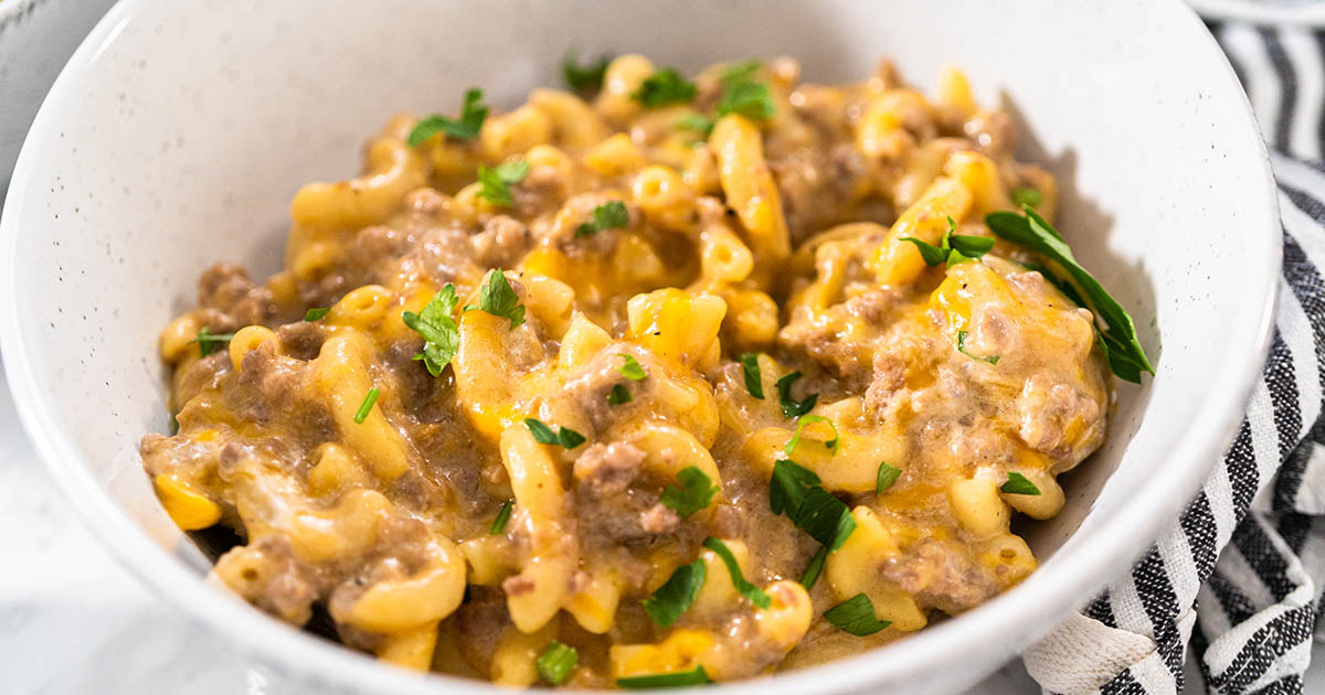 Serving homemade hamburger helper in white ceramic bowls.