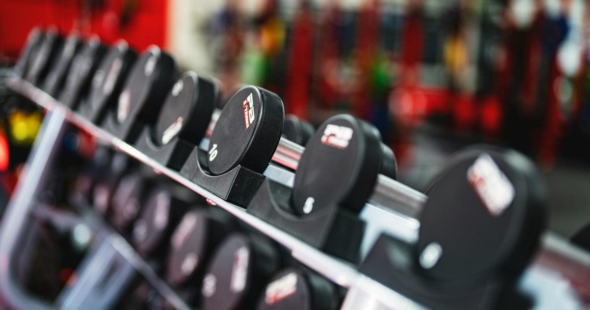 Close-up view of dumbbells in a modern gym setting, emphasizing fitness and training.