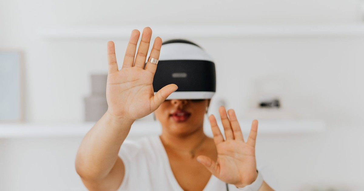 A woman interacts with virtual reality technology using a VR headset indoors.