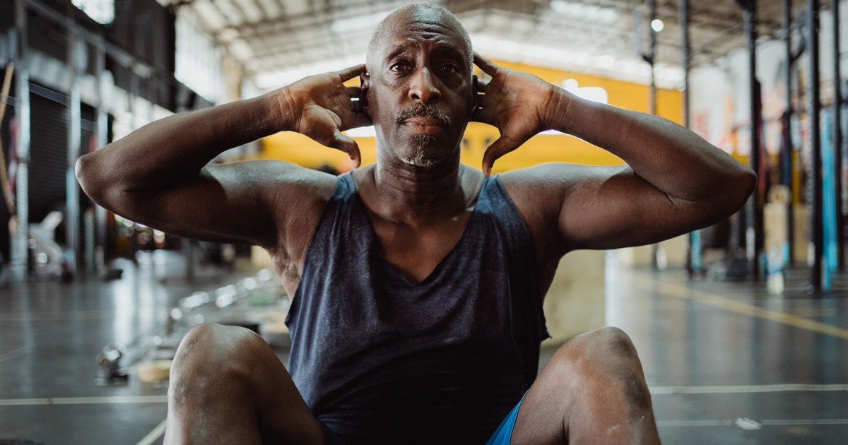 Focused mature man performing sit-ups in a gym. Fitness and determination.