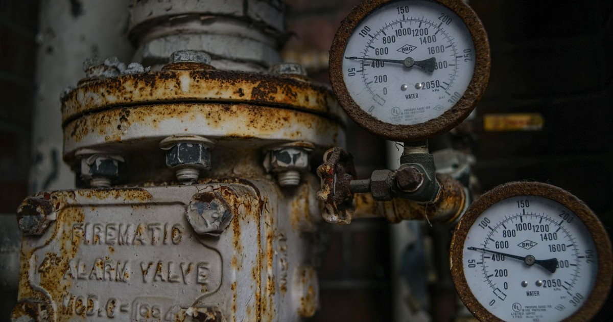 Close-up of an aged and rusted pressure valve with gauges showing readings.