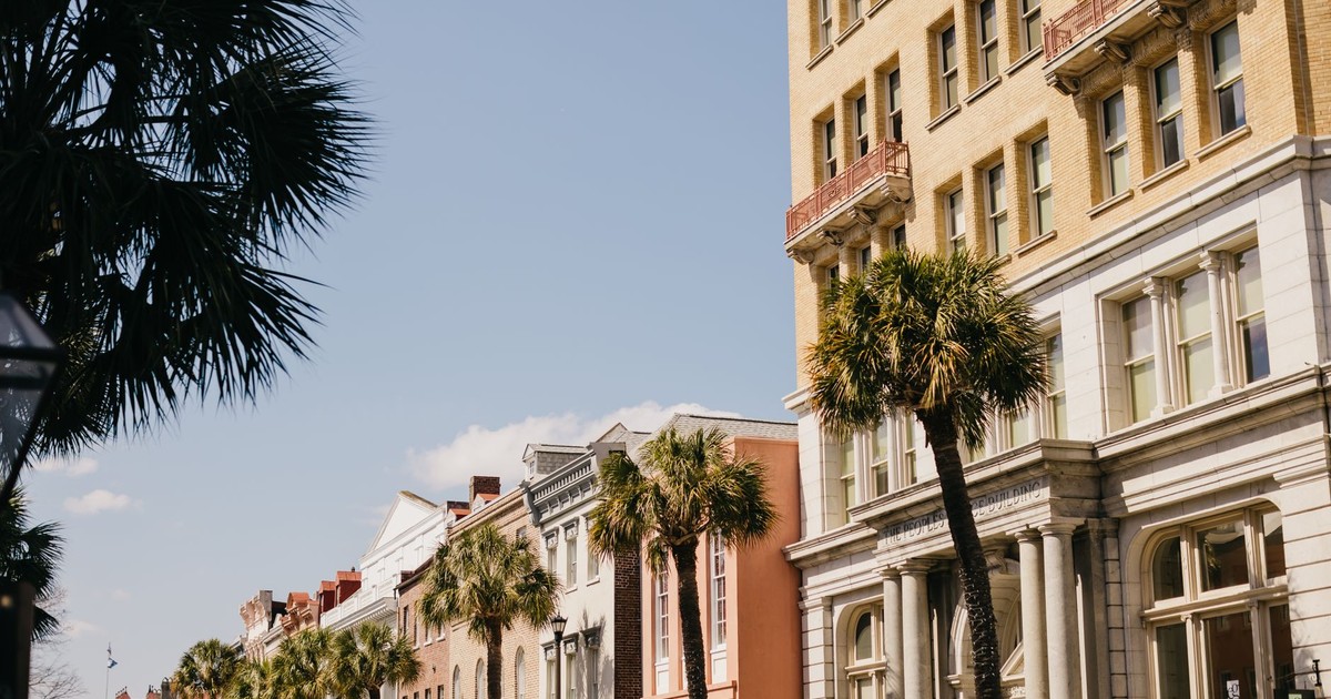 Charming street view of historical buildings and palm trees in Charleston, SC.
