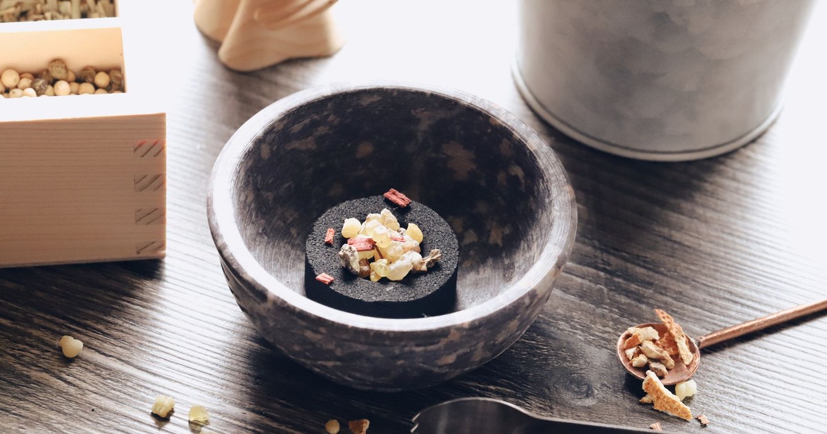 A beautifully arranged mix of incense ingredients in a rustic bowl, captured on a wooden table with natural light.