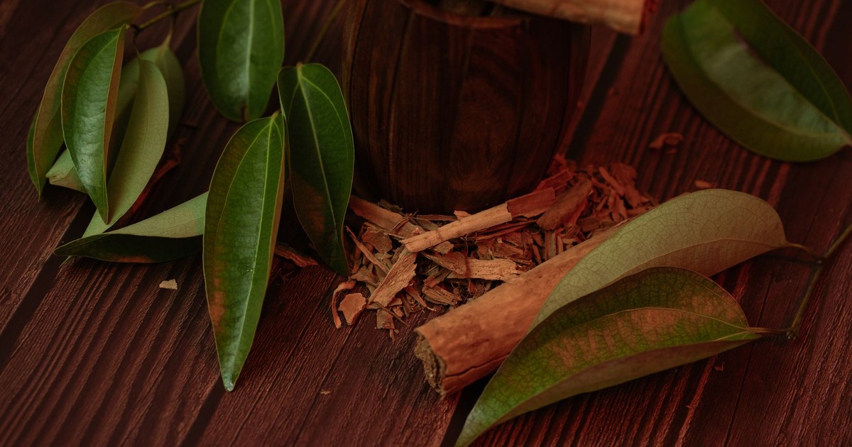 Cinnamon sticks and leaves on a wooden surface, highlighting their natural beauty.