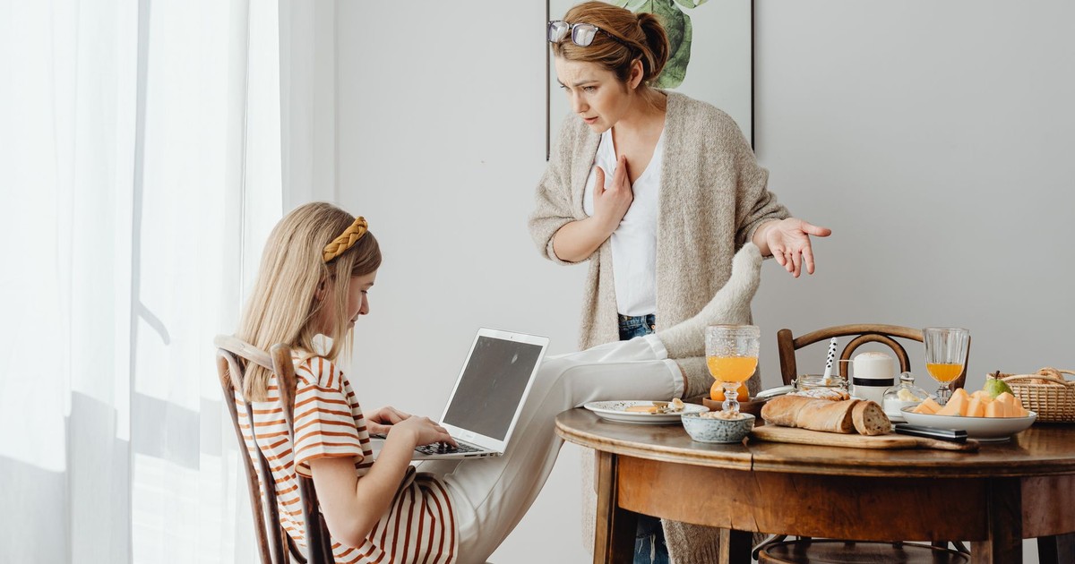 Mother and daughter having a discussion over breakfast with a laptop.