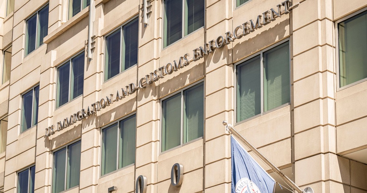 Exterior view of the US Immigration and Customs Enforcement building with a visible flag and signage.