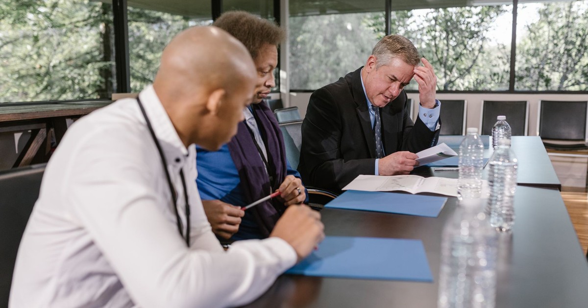 Group of diverse colleagues in a business meeting reviewing documents indoors.