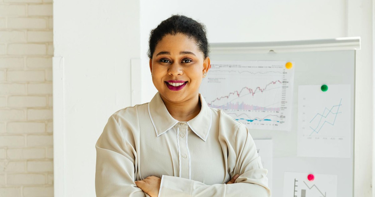 Businesswoman standing confidently with charts in modern office setting.