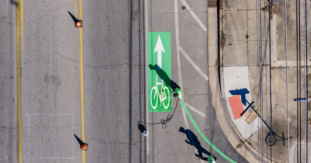 Aerial view of workers painting a green bike lane on a street in Chattanooga, Tennessee.