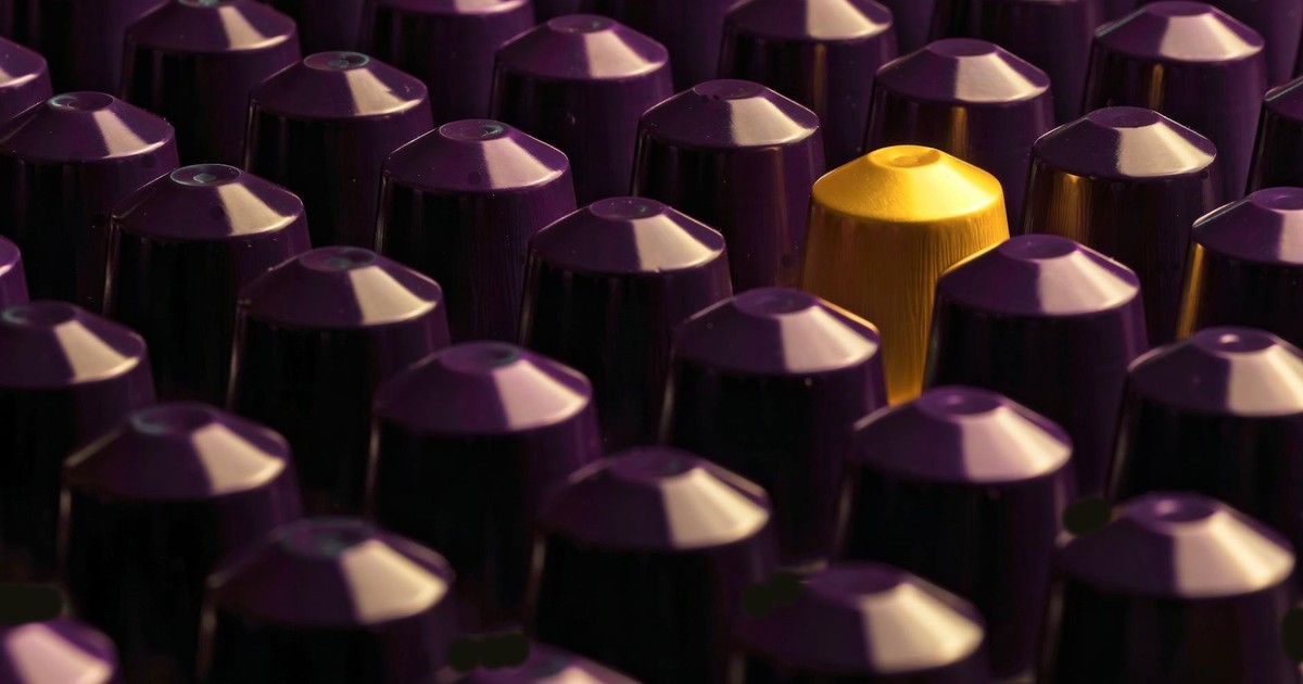 An artistic display of purple coffee pods with a standout gold pod.