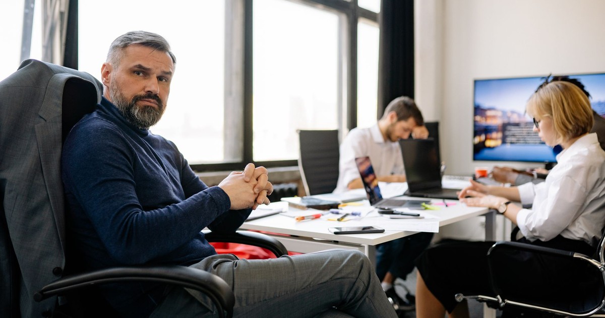 Co-workers engaging in a business discussion in a modern office setting.