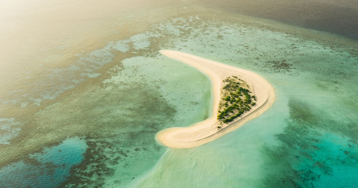 Stunning aerial view of a secluded sandbank surrounded by turquoise waters in the Maldives.