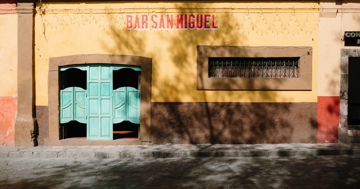Yellow Mexican bar facade with turquoise doors in San Miguel de Allende.