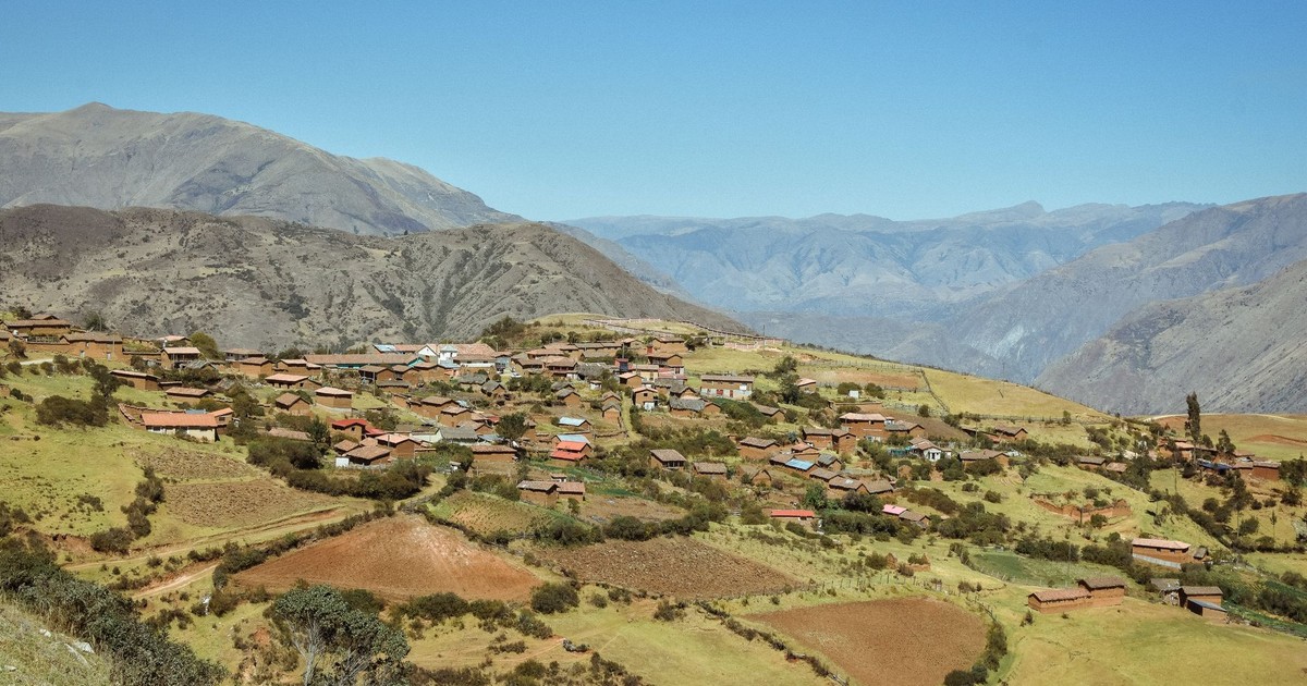 Scenic aerial view of Chonta village in Peru's Andean highlands with majestic mountains and green fields.