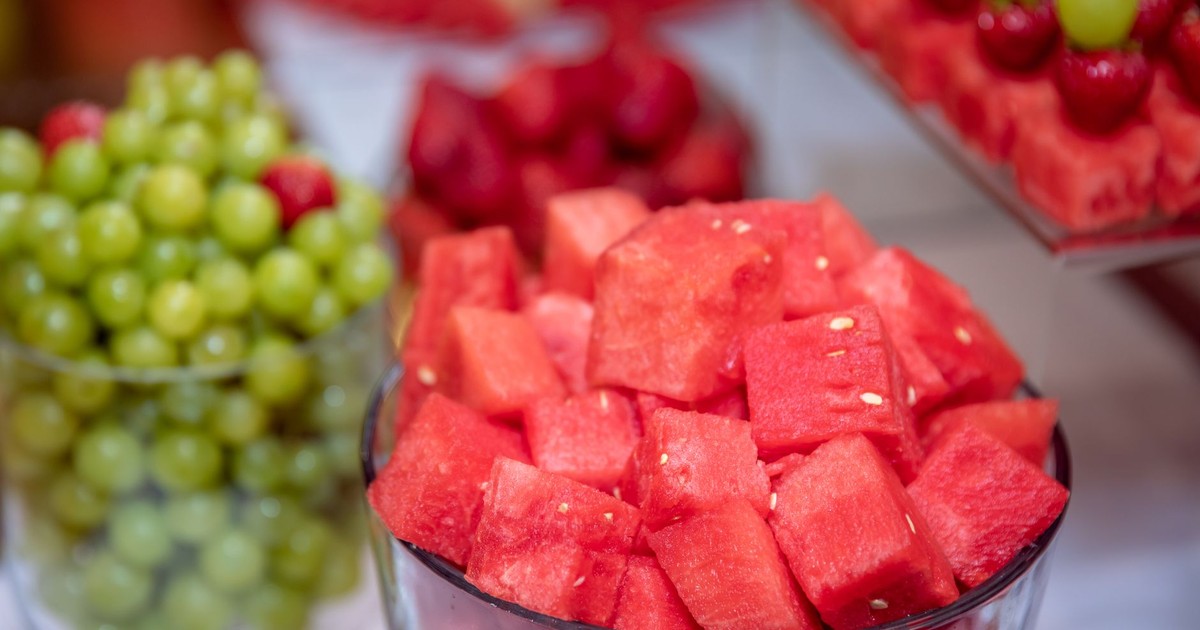 Colorful close-up of watermelon cubes with grapes and strawberries, perfect for summer refreshment.