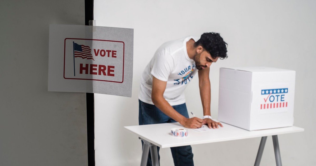 A man casting his vote in a ballot box, highlighting the democratic process in a studio setting.