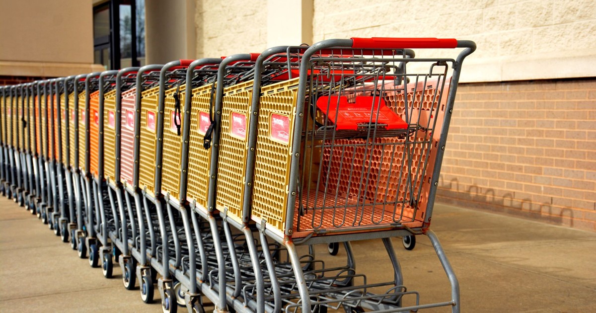 Bright row of stacked shopping carts lined up in front of a retail store on a sunny day.