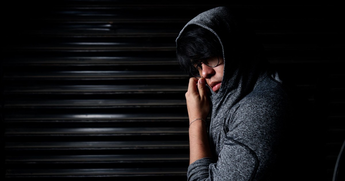 Mysterious portrait of a man in a hoodie, blending into shadows.
