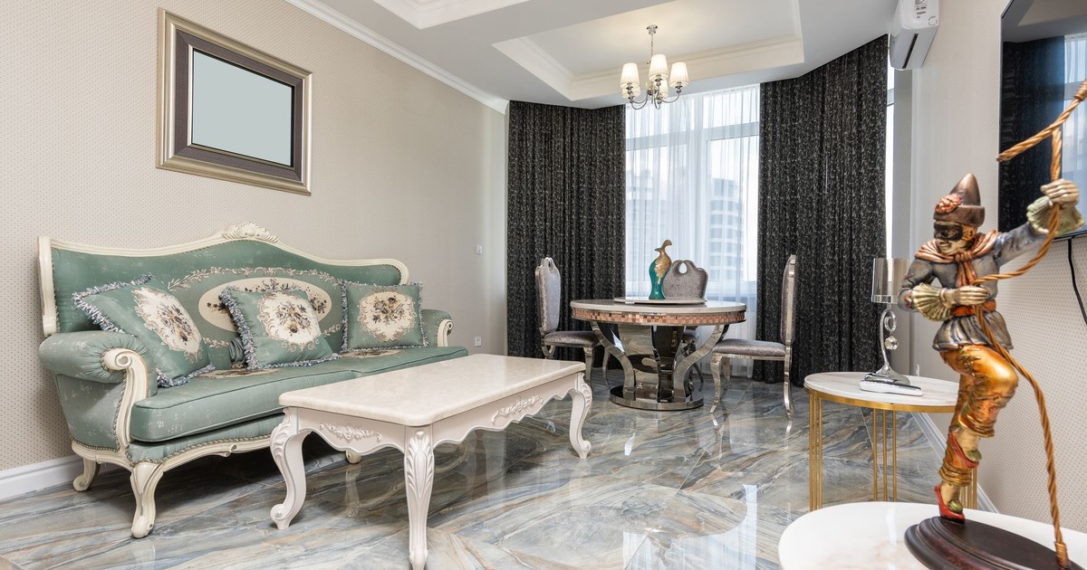 Room interior with classic sofa against tables and statuette of gladiator near wall with television in apartment