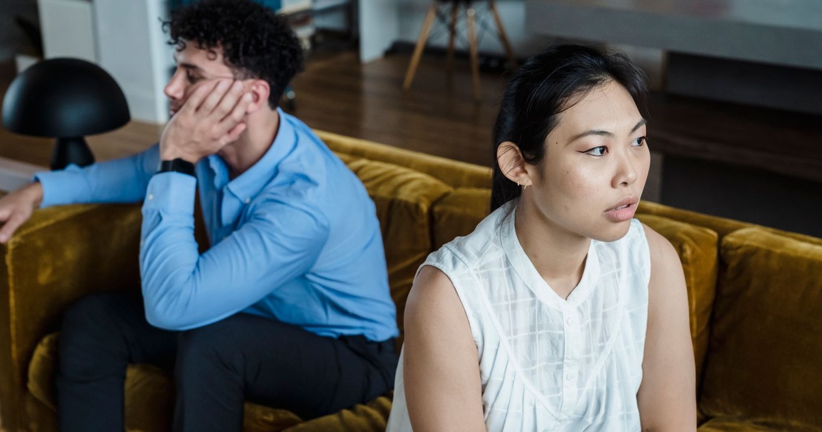 A serious moment between a couple sitting on a couch, highlighting tension and communication issues.