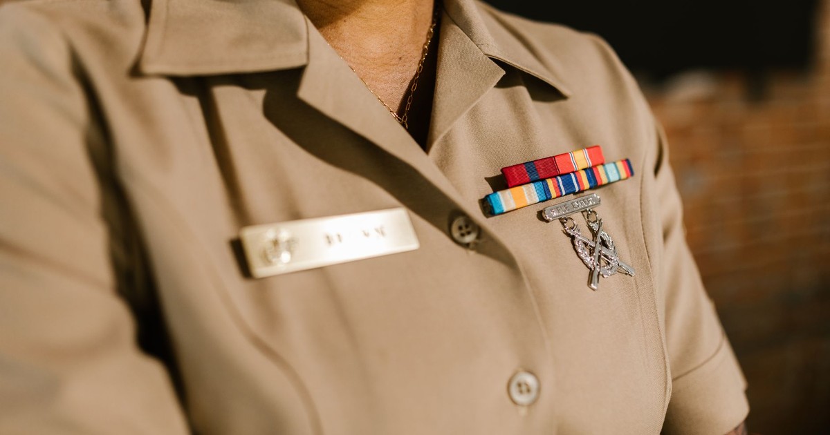 A detailed shot of a military uniform displaying medals and identification badges representing achievement and honor.