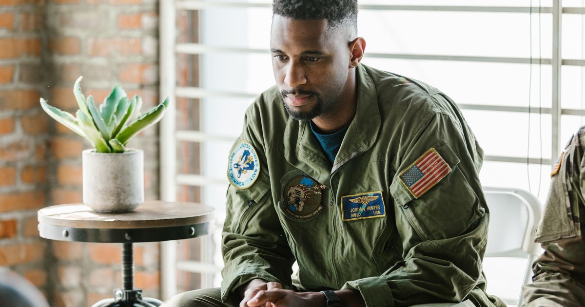 Thoughtful military veteran in uniform listening intently indoors.