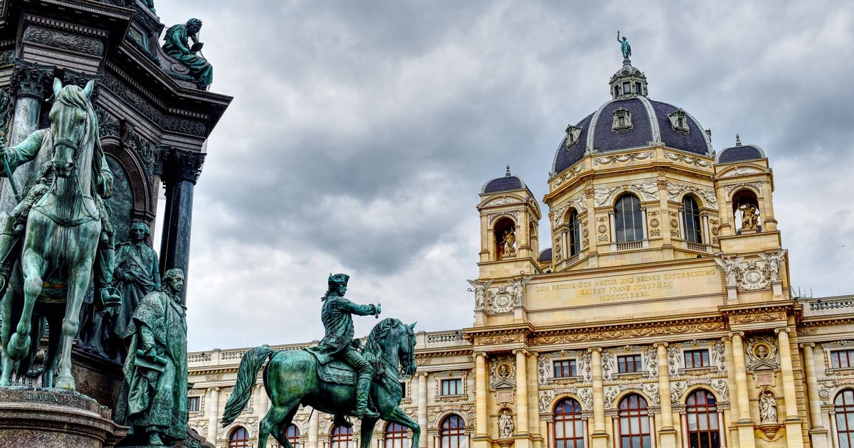 Magnificent view of Vienna's Kunsthistorisches Museum and the Maria Theresa monument under a cloudy sky.