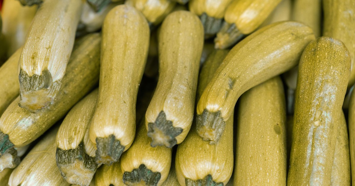 Close-up of fresh zucchinis at a market, showcasing their nutritious appeal and abundance.