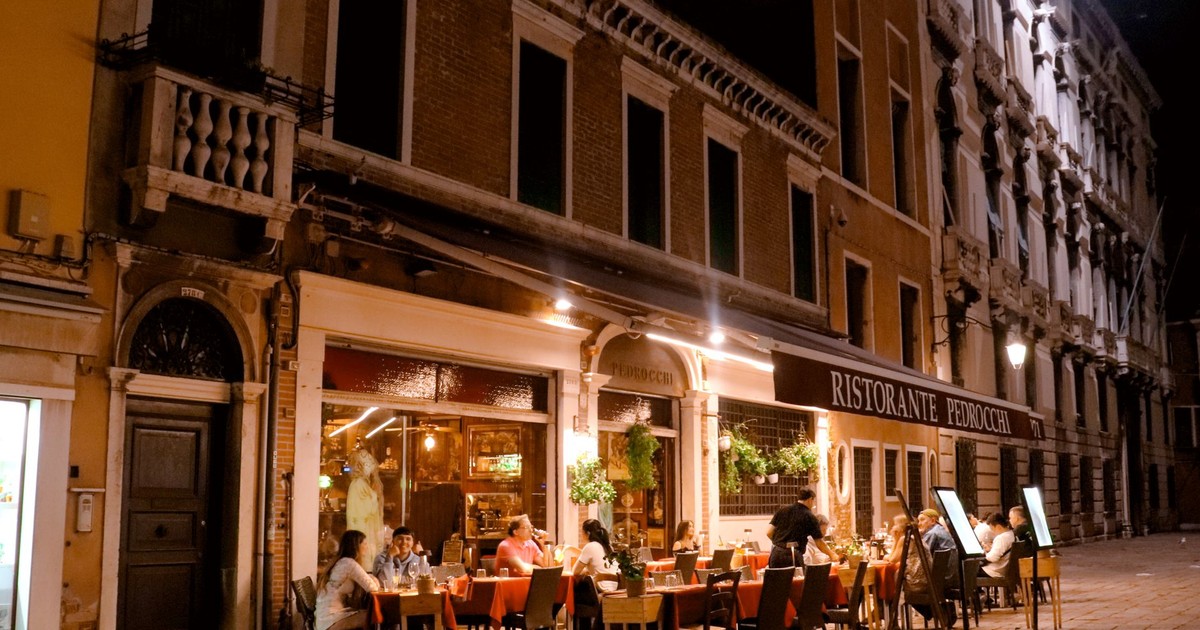 Charming evening ambiance of diners enjoying a meal at Ristorante Pedrocchi in Venice, Italy.