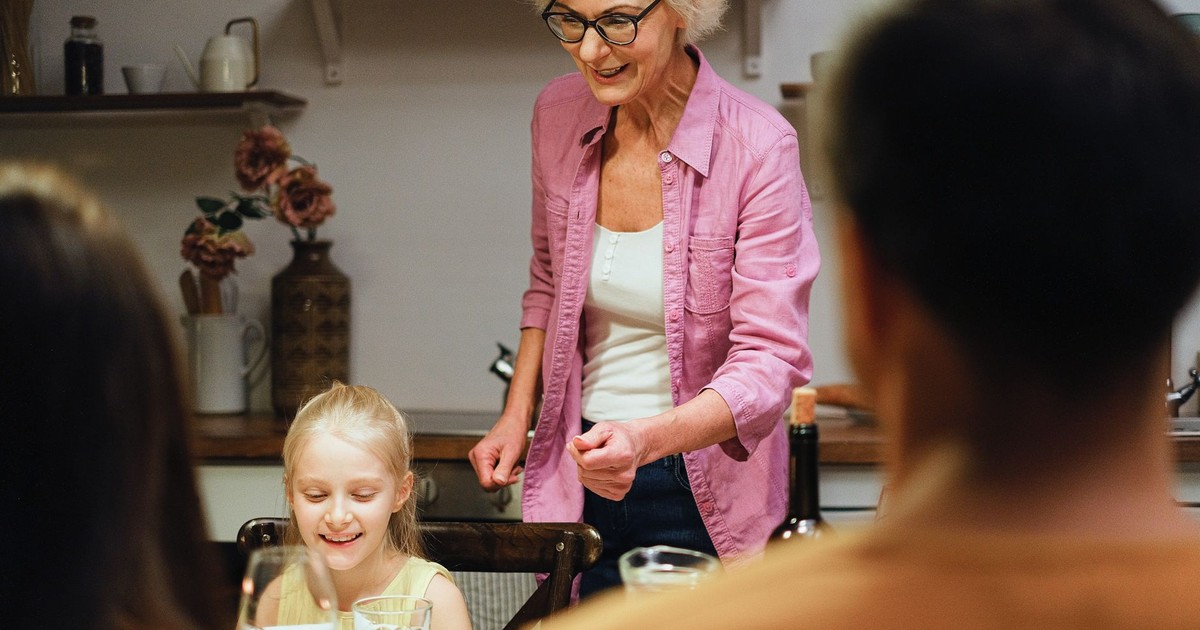 A joyful family gathering around the dinner table, showcasing togetherness and warmth indoors.