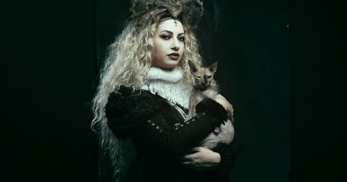 A mysterious woman in a crown holds a cat, embodying a gothic royal theme.