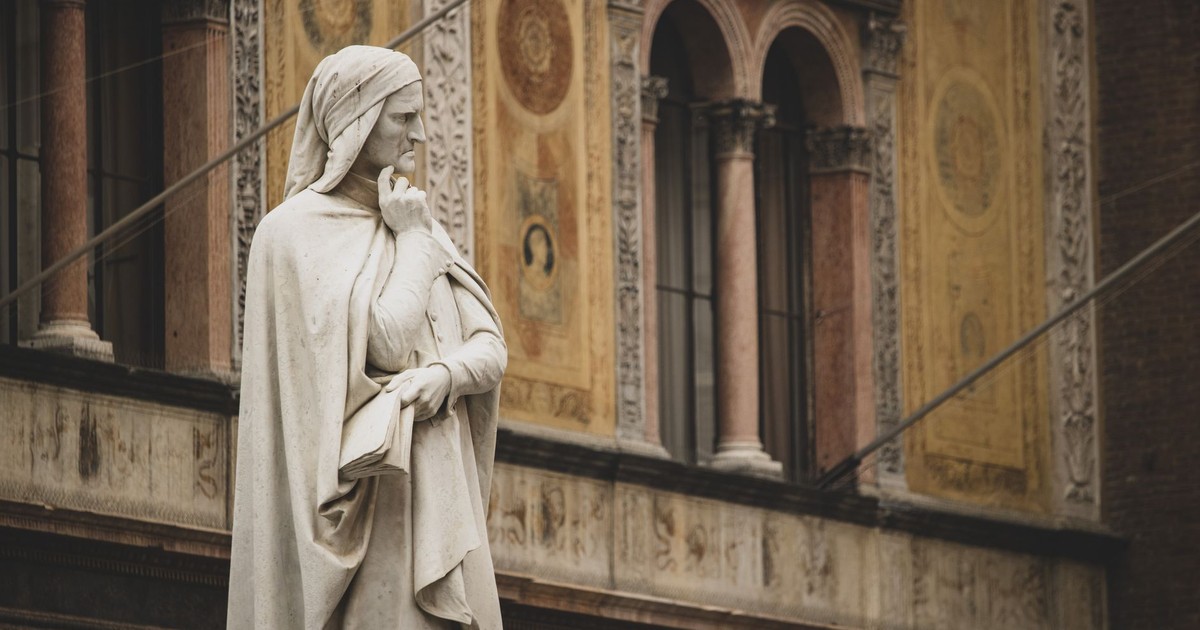 Statue of Dante Alighieri in front of historical building in Verona, Italy.
