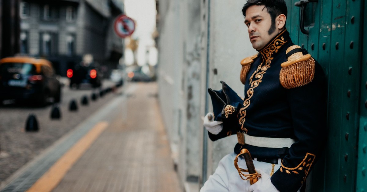 A man in period military costume poses in an urban setting in Buenos Aires, Argentina.