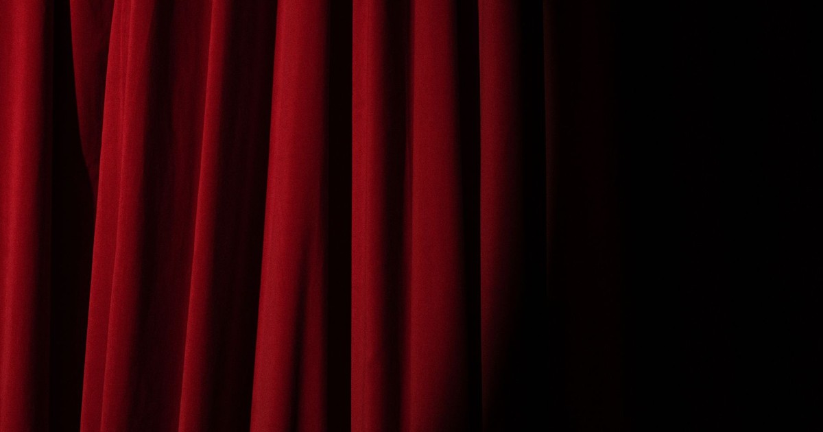 Elegant red velvet curtain with dramatic lighting perfect for theater themes.
