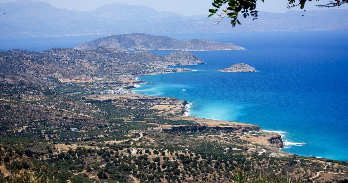 Breathtaking view of Crete's coastline with blue sea and rugged terrain under a clear sky.