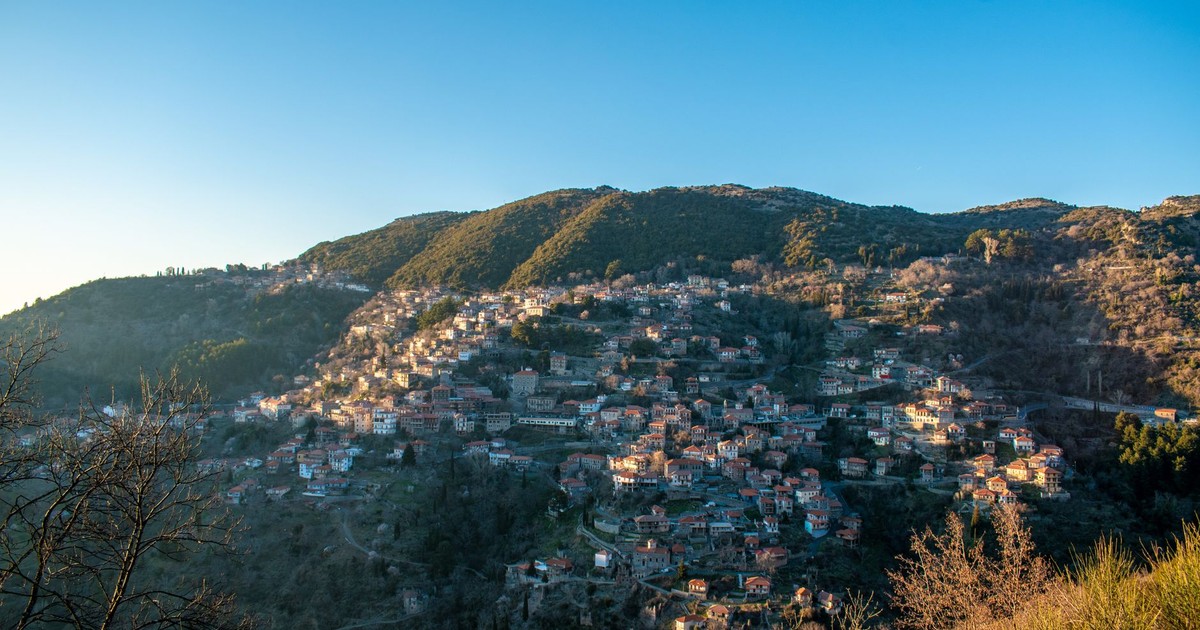 Explore the charming hillside village of Lagkadia, Greece, bathed in warm sunset hues.