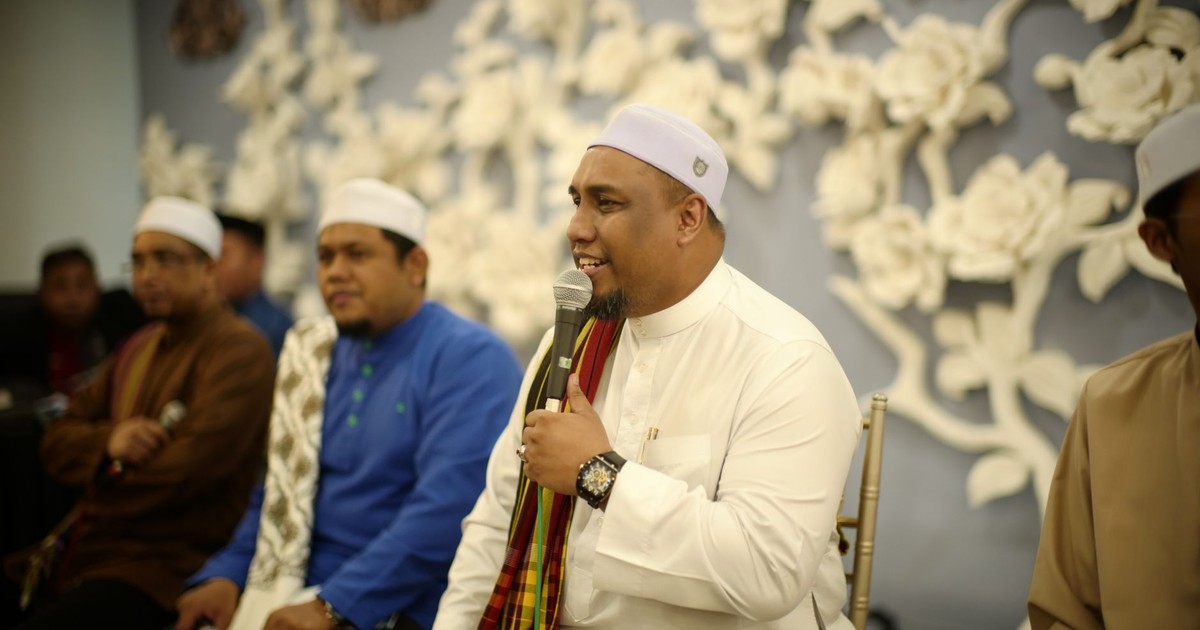 Muslim men in traditional attire engage in a religious gathering in Kuala Lumpur, Malaysia.