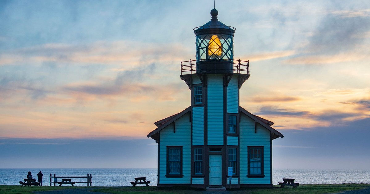 Serene view of Point Cabrillo Lighthouse at twilight against a colorful sky on the Mendocino coast.