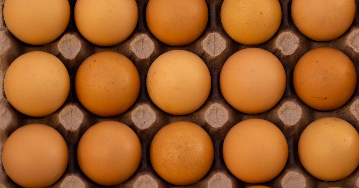 Top view of fresh brown eggs neatly placed in a cardboard egg tray.