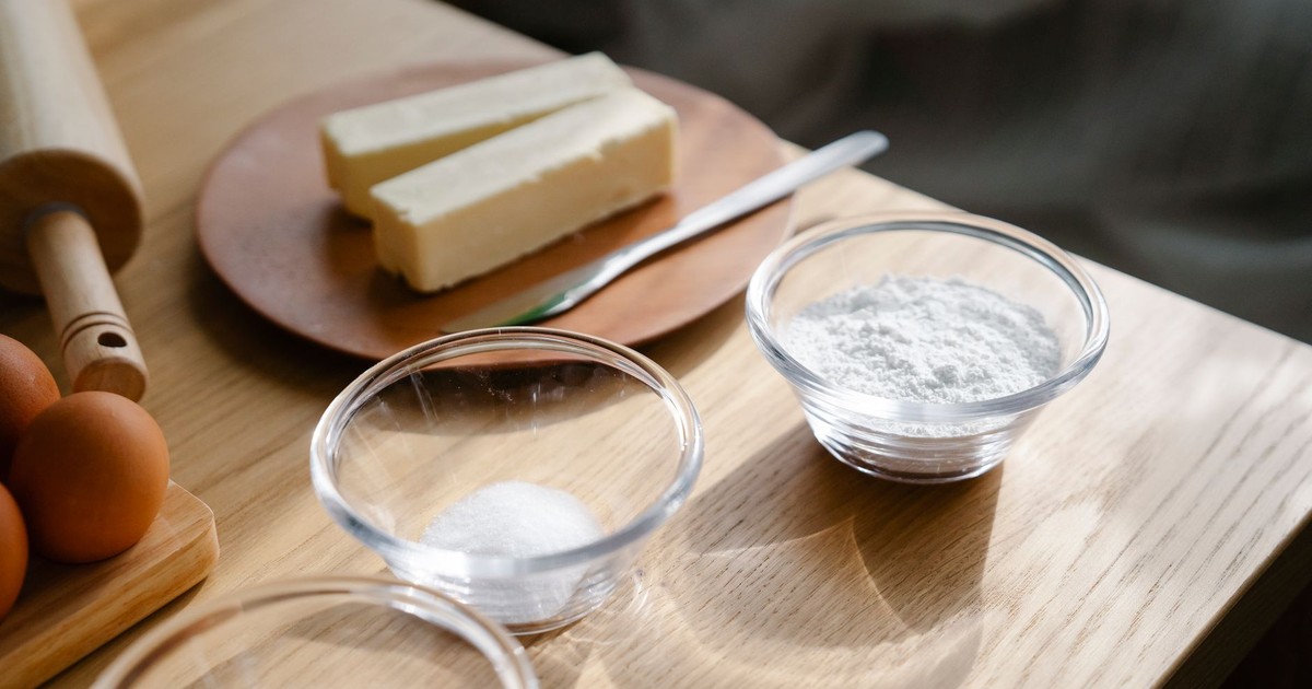 Close-up of baking ingredients on a wooden table with natural lighting.