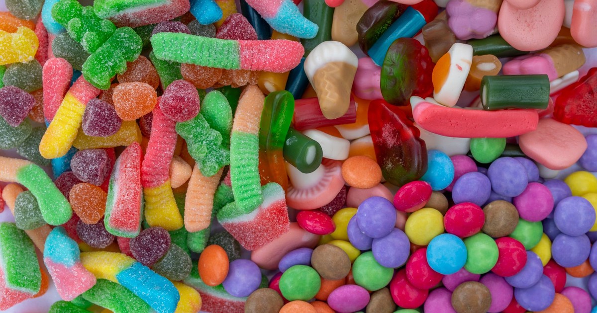 A vivid collection of assorted gummy worms, jellybeans, and candy-coated chocolates.