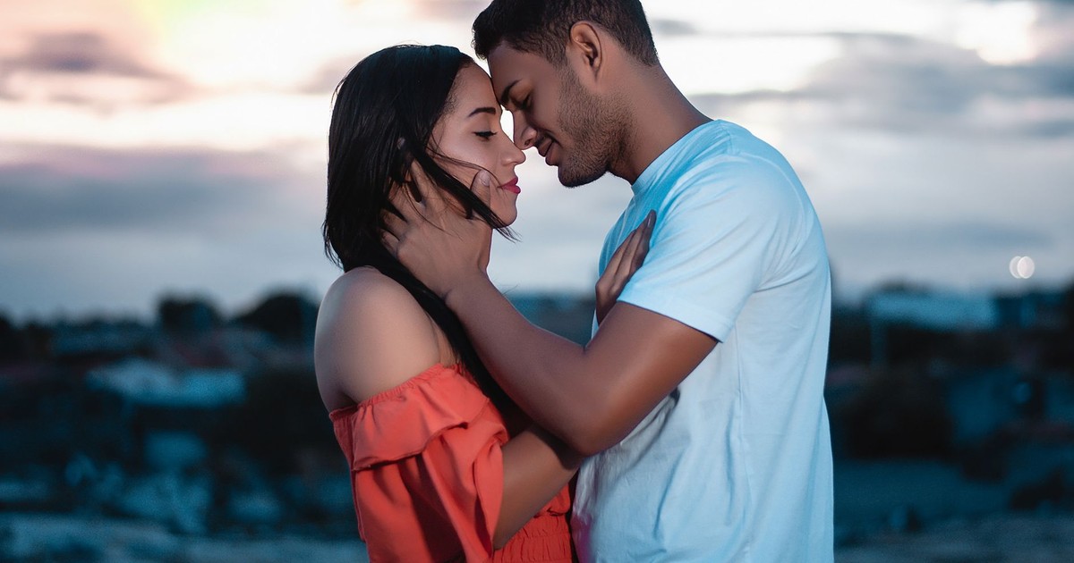 A loving couple embraces during a beautiful sunset outdoors, symbolizing romance and togetherness.