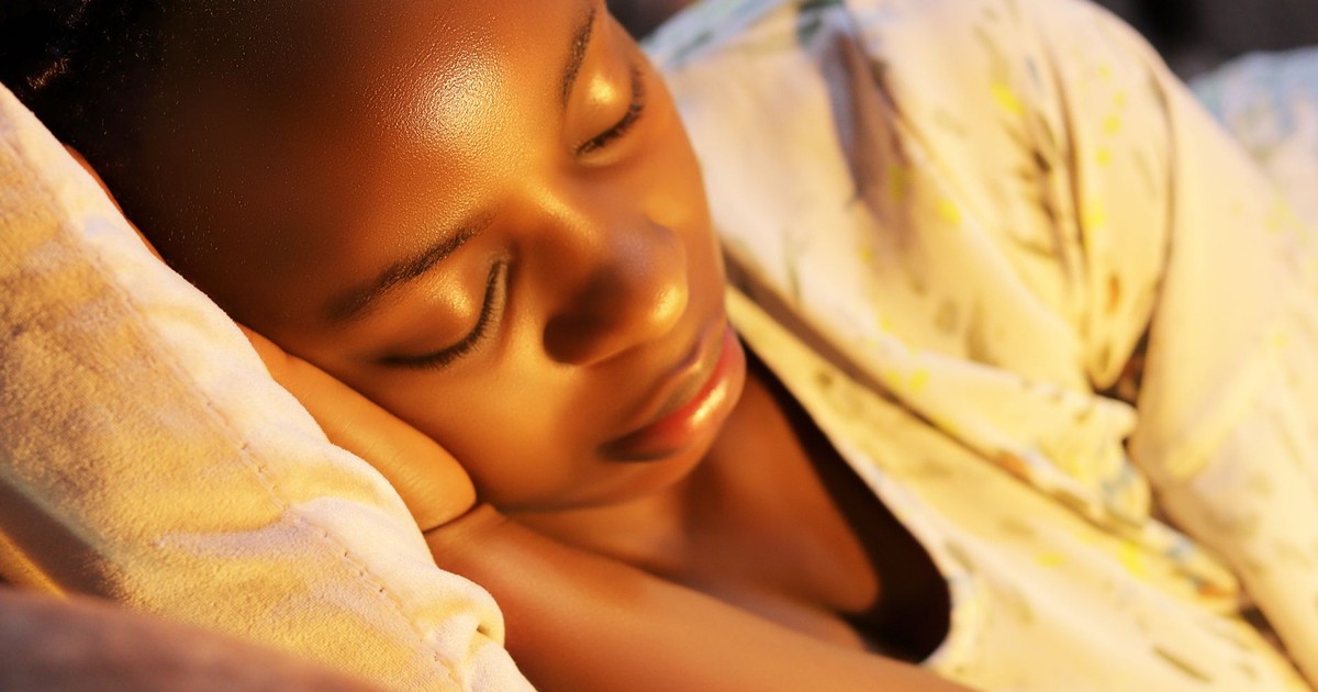 A serene close-up of a young woman sleeping peacefully indoors.
