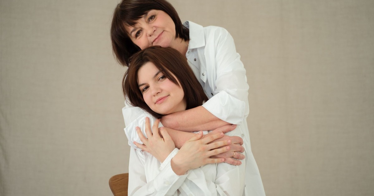 A heartwarming studio portrait of a mother embracing her daughter with love and affection.