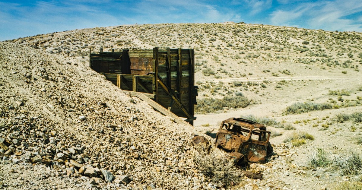 Explore the barren landscape of a deserted mine in Nevada, featuring a rusty vehicle.