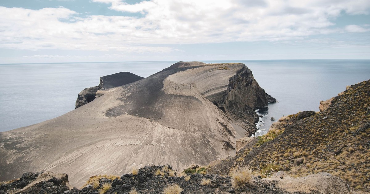 Explore this breathtaking coastal cliff formed by ancient volcanic activity beside a serene sea.