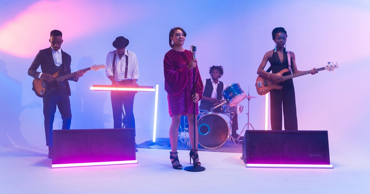 A vibrant band performing on stage with neon lights and musical instruments, showcasing talent and energy.