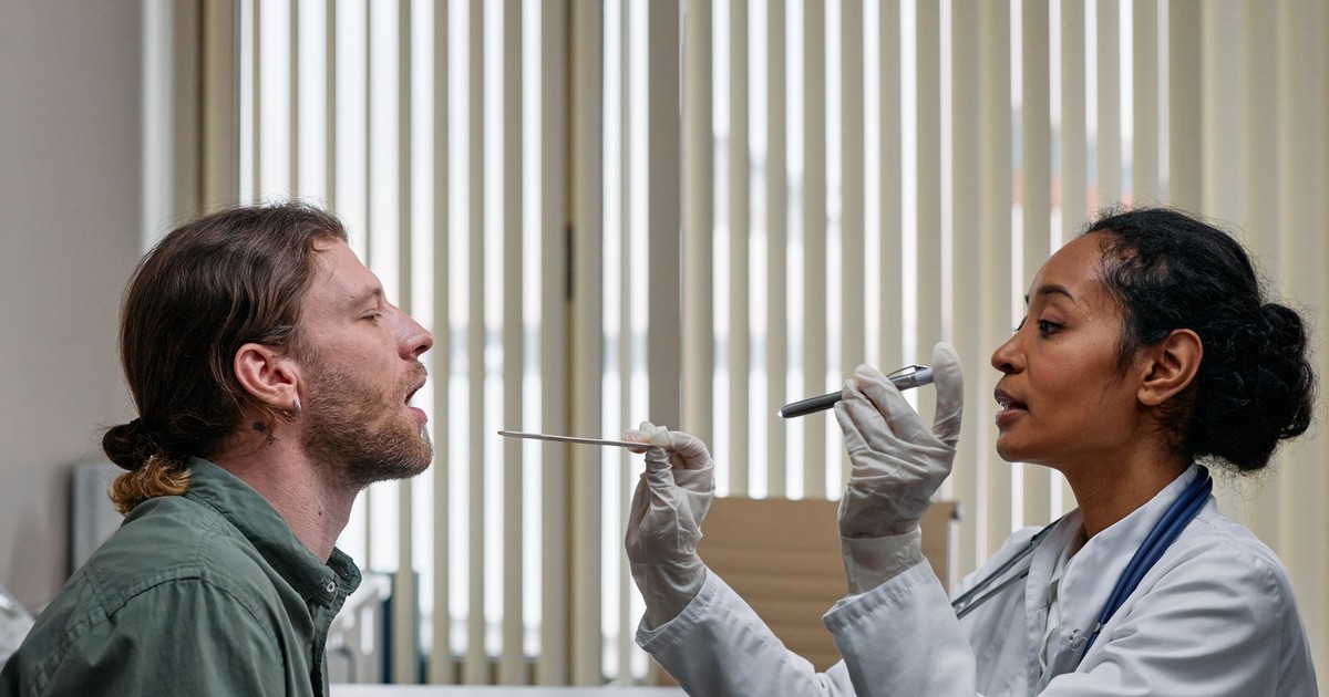 A doctor examining a patient's throat in a clinical setting, highlighting professional healthcare.